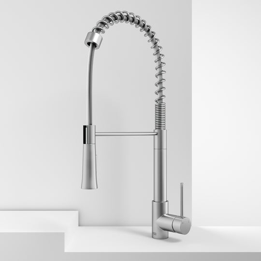 Deck-mounted kitchen faucet with included hose, sprayer head, and stainless steel finish