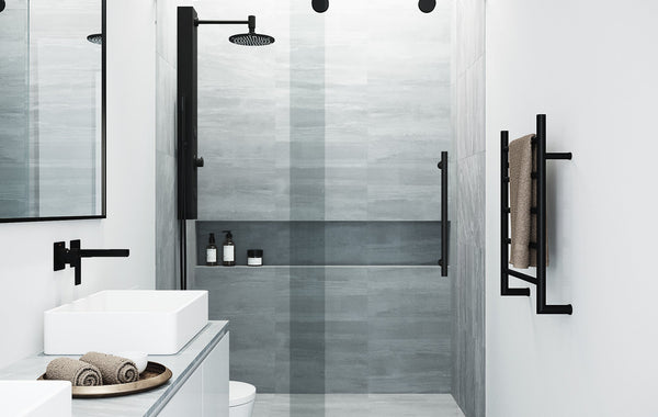 Interior of modern light bathroom with toilet and bidet next to bath and sink with faucet on cabinet under mirror