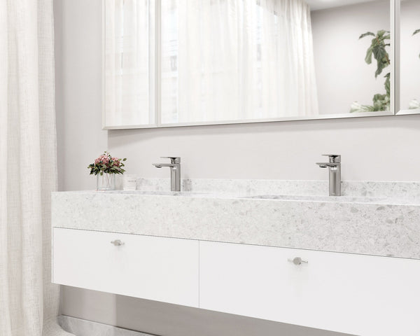 A brushed-nickel single-hole bathroom faucet styled on a modern vanity