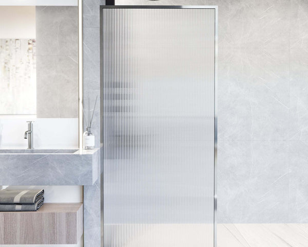 Open walk-in shower with a single fixed glass screen and a level, curbless tile floor