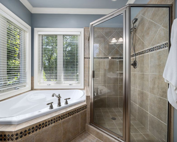 Elegant bathroom with glass shower, soaking tub, and large windows offering natural light.