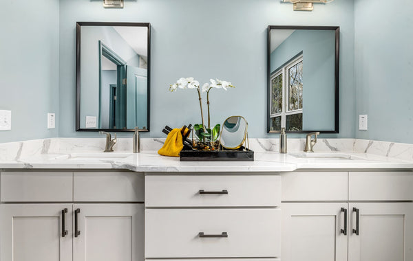 A serene modern bathroom featuring twin sinks, elegant faucets, and decorative mirrors.