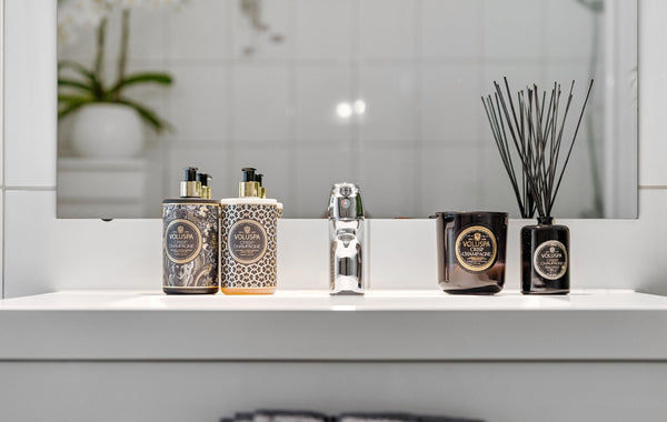 Elegant bathroom display with luxury accessories and sleek reflection.