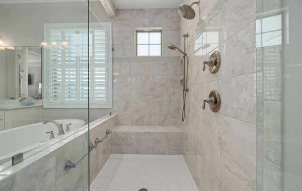 Modern bathroom interior showcasing a luxurious shower with white tiles and glass doors.