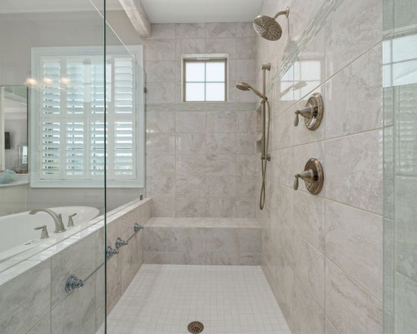 Modern bathroom interior showcasing a luxurious shower with white tiles and glass doors.