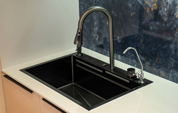 A sleek black kitchen sink with a modern faucet and marble backsplash, ideal for contemporary interiors.