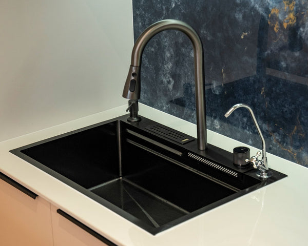 A sleek black kitchen sink with a modern faucet and marble backsplash, ideal for contemporary interiors.