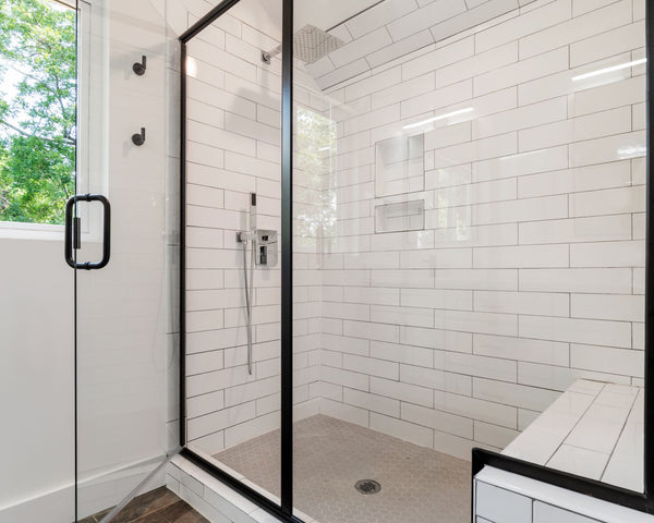 Sleek and modern shower with glass panels and tiled walls in a bright bathroom.