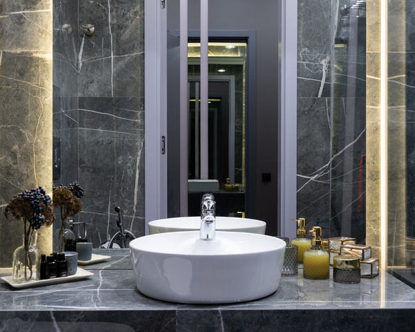 Contemporary bathroom with washstand between plant sprigs and hygiene products against mirror in house