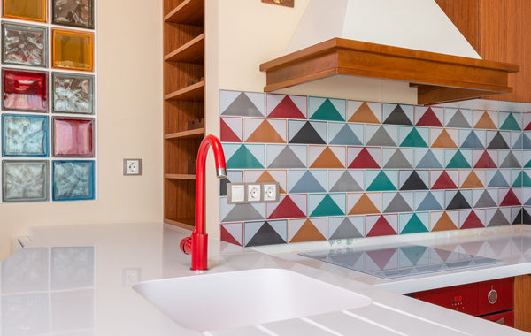 Interior of stylish kitchen with colorful tile and red faucet in modern apartment