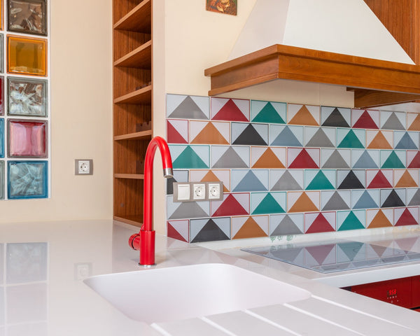 Interior of stylish kitchen with colorful tile and red faucet in modern apartment