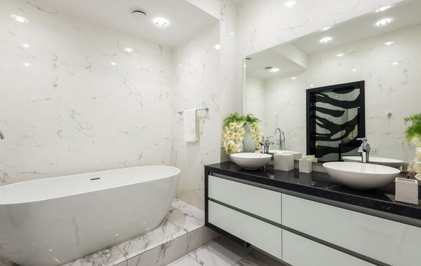 Interior of contemporary bathroom with white marble bathtub tiled walls and floor and cabinet under sink with chrome faucet