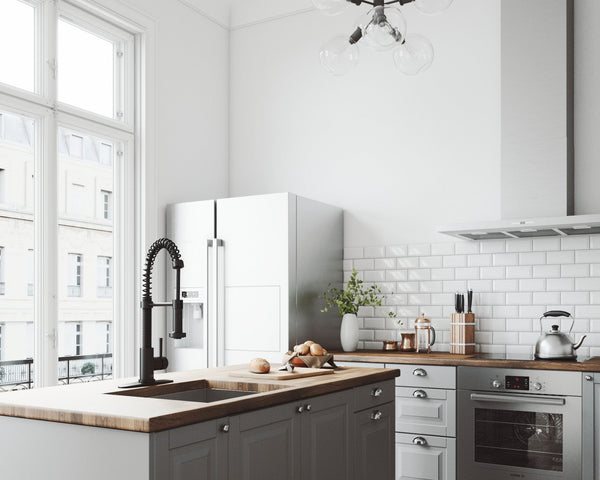 VIGO Edison pull-down kitchen faucet in matte black on a deck plate at a wood-topped island in a bright white kitchen with gray cabinets