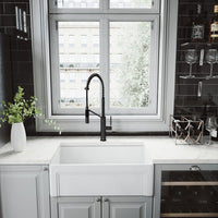 Single handle faucet with gooseneck spout, pull-down sprayer, and matte black finish
