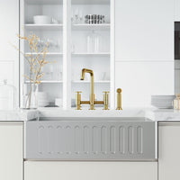 Deck mount kitchen faucet with included supply lines and sprayer head in matte brushed gold